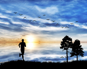 man running by the lake under clouds of colors