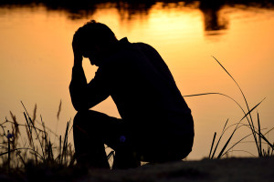Depressed Man Sitting On Top Of Hands